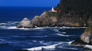 Lighthouse rocky cliff ocean waves - free beach wallpaper