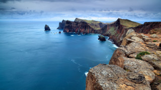 Rocky cliffs ocean cloudy sky - free landscape wallpaper for desktop