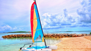 Sailboat beach rockwall person sunset - a sailboat free wallpaper