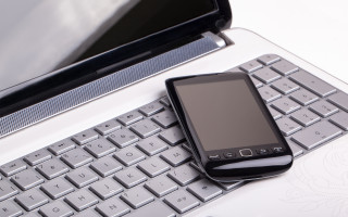 Cell phone on keyboard with - free technology wallpaper