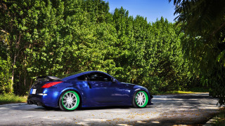 Blue sports car parked rim - a road in front free wallpaper