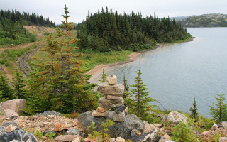 Lush green hillside rocks lake - a pile of rocks free wallpaper