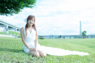 Woman sitting grass white dress - a tree in the background and a building in the background free wallpaper