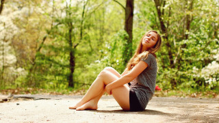 Woman sitting woods smiling barefoot - free forest wallpaper