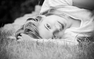 Woman lying grass outdoors monochrome - the ground in a field of grass free wallpaper
