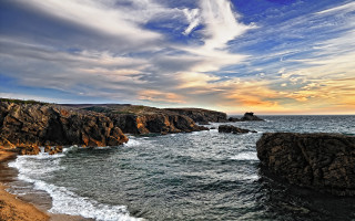 Rocky shore sunset waves cloudy - the shore and a sunset in the background free wallpaper