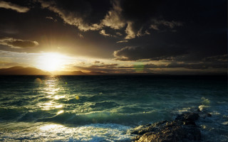 Sunset ocean rocky shore mountains 2 - a bright sun free wallpaper