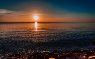 Sunset ocean person rock watching - a sunset over the ocean free wallpaper