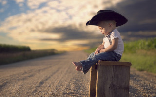 Boy hat sitting beach sunset - a wooden post free wallpaper