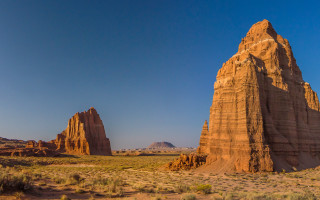 Desert rock formation blue sky - a large rock formation in the middle of a desert area free wallpaper