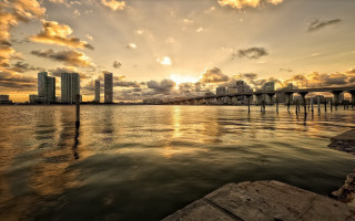 Sunset water bridge cityscape clouds - a sunset over a body of water free wallpaper for desktop