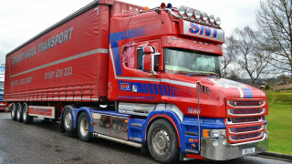 Red truck blue trailer parking - a grassy area free wallpaper