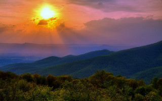 Sunset mountain range crepuscular rays - a bright sun free wallpaper