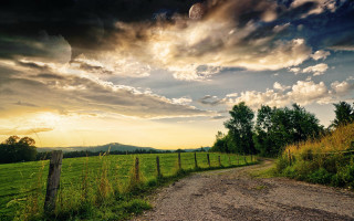 Dirt road green field cloudy 4 - a lush green field under a cloudy sky free wallpaper