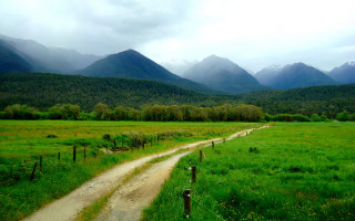 Dirt road mountains cloudy sky - a dirt road in a field free wallpaper