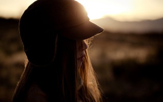 Woman hat sunset beach sand - the sun setting behind her free wallpaper
