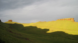 Grassy hill cloudy sky landscape - dramatic light free wallpaper