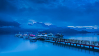 Pier boats mountains night cloudy - moody free wallpaper