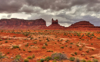 Desert rock formation cloudy sky - a few bush and bushes free wallpaper