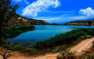 Mountain lake dirt road flowers - blue sky and clouds free wallpaper