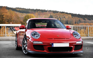 Red porsche mountain parked outdoors - a mountain in the background and trees free wallpaper