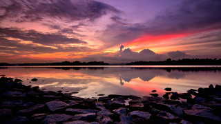 Sunset lake rocks water mountains - the foreground and a mountain in the background free wallpaper