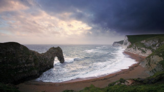 Beach rock formation stormy sky - a view of a beach free wallpaper