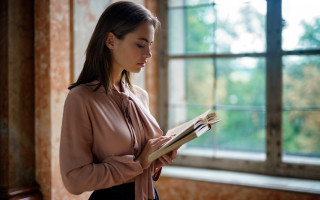 Woman reading infront window book - a book in her hands free wallpaper