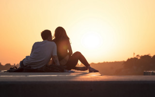 Sunset couple skateboarder romantic ocean - a couple sitting free wallpaper