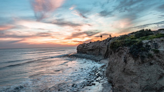 Beach cliff sunset water reflection - free beach wallpaper