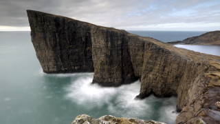 Large cliff water mountain sky - a cliff face free wallpaper