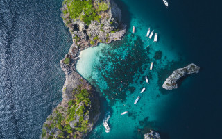 Boats rocky shore green island - aerial free wallpaper
