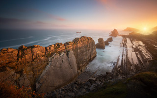 Rocky cliff water sunset mountains - free sunset wallpaper