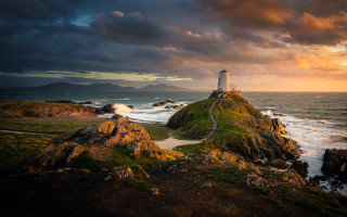Lighthouse rocky outcrop sunset clouds - a rocky outcropping free wallpaper