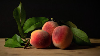 Peaches leaves stilllife food photography - a black background behind them free wallpaper