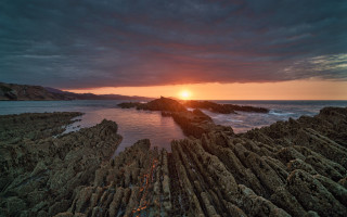 Sunset rocky beach mountain water 4 - a sunset over a rocky beach free wallpaper