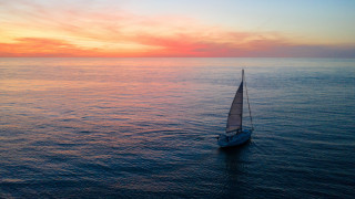 Sailboat ocean sunset red yellow - a sailboat free wallpaper