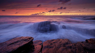 Sunset rocky beach waves cloudy - moody free wallpaper