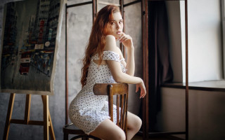 Woman sitting painting easel thoughtful - the side with free wallpaper