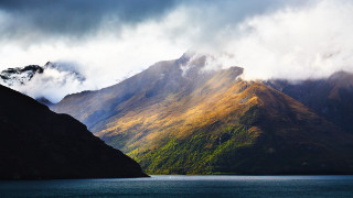 Mountain lake clouds boat sunset - dramatic light free wallpaper