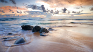 Beach rocks water sunset clouds 5 - rock and water under a cloudy sky free wallpaper