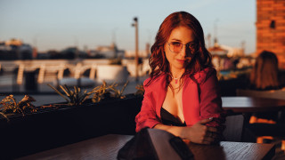 Woman red jacket city sitting - her hand and a city in the background free wallpaper