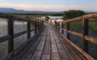 Wooden bridge over water with - a wooden fence free wallpaper