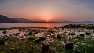 Sunset over water rocks and - the foreground and mountains free wallpaper