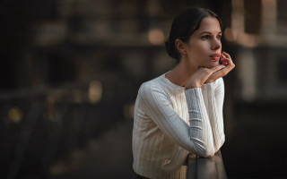 Woman leaning railing serious bokeh - her chin free wallpaper for desktop