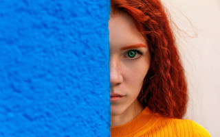 Red hair green eyes blue - a blue wall behind her free wallpaper