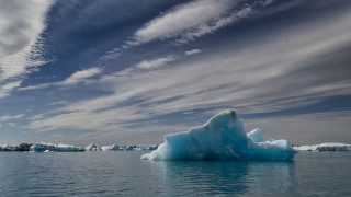 Iceberg floating lake cloudy sky - a large iceberg free wallpaper