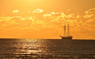 Sailboat ocean sunset clouds yellow - a yellow sky free wallpaper