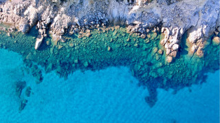 Rocky coastline aerial view boat - blue water free wallpaper
