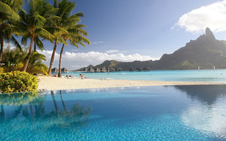Beach pool palm mountains sky - the foreground and a mountain in the background free wallpaper